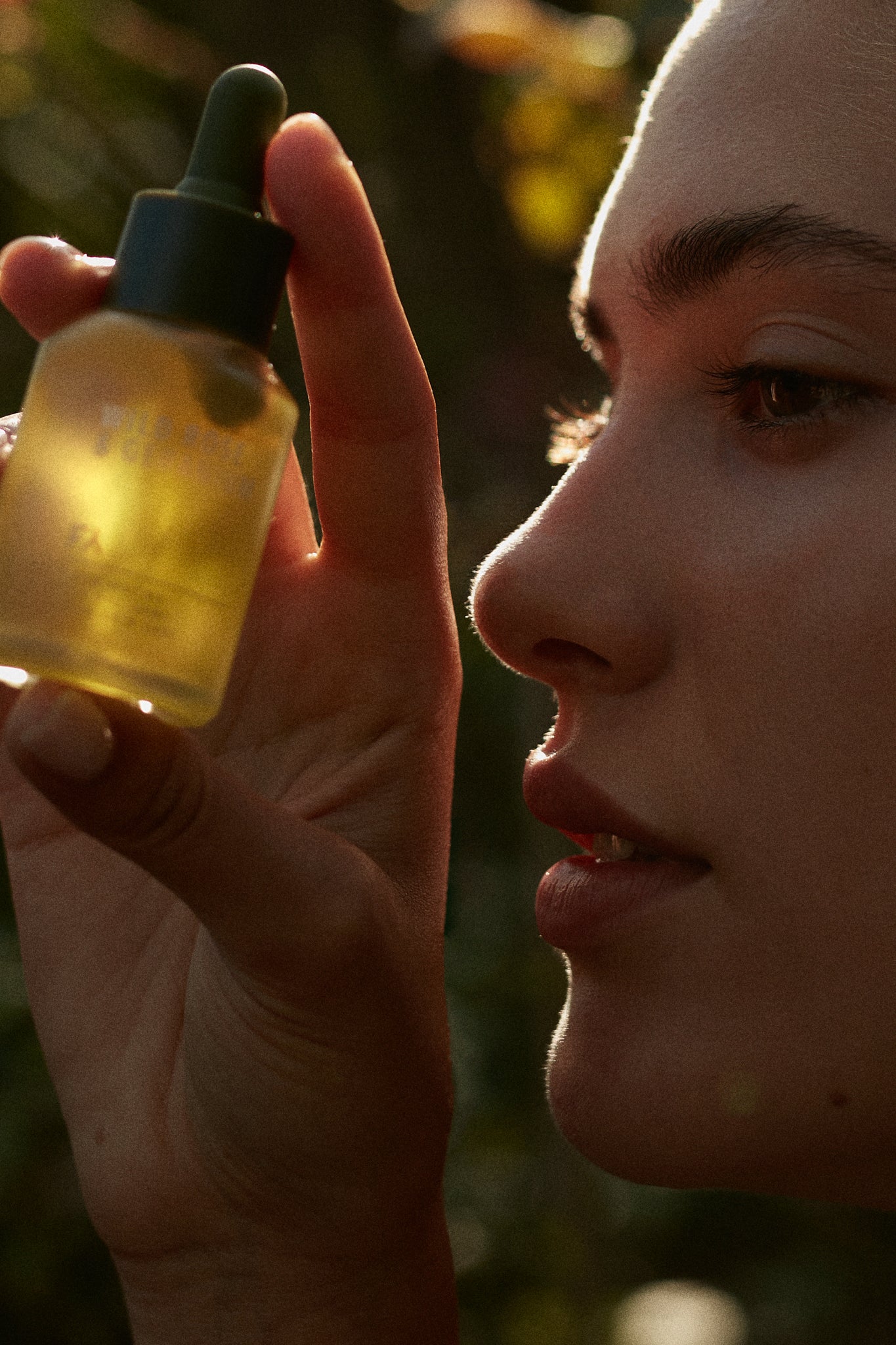 Wild Rose & Geranium Illuminating Face Oil by Fields of Yarrow being held by a beautiful girl in the nature