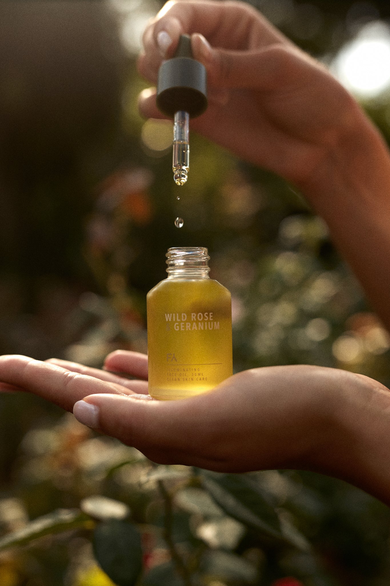 Picture in the nature of the Wild Rose & Geranium Illuminating Face Oil by Fields of Yarrow being picked out of the bottle