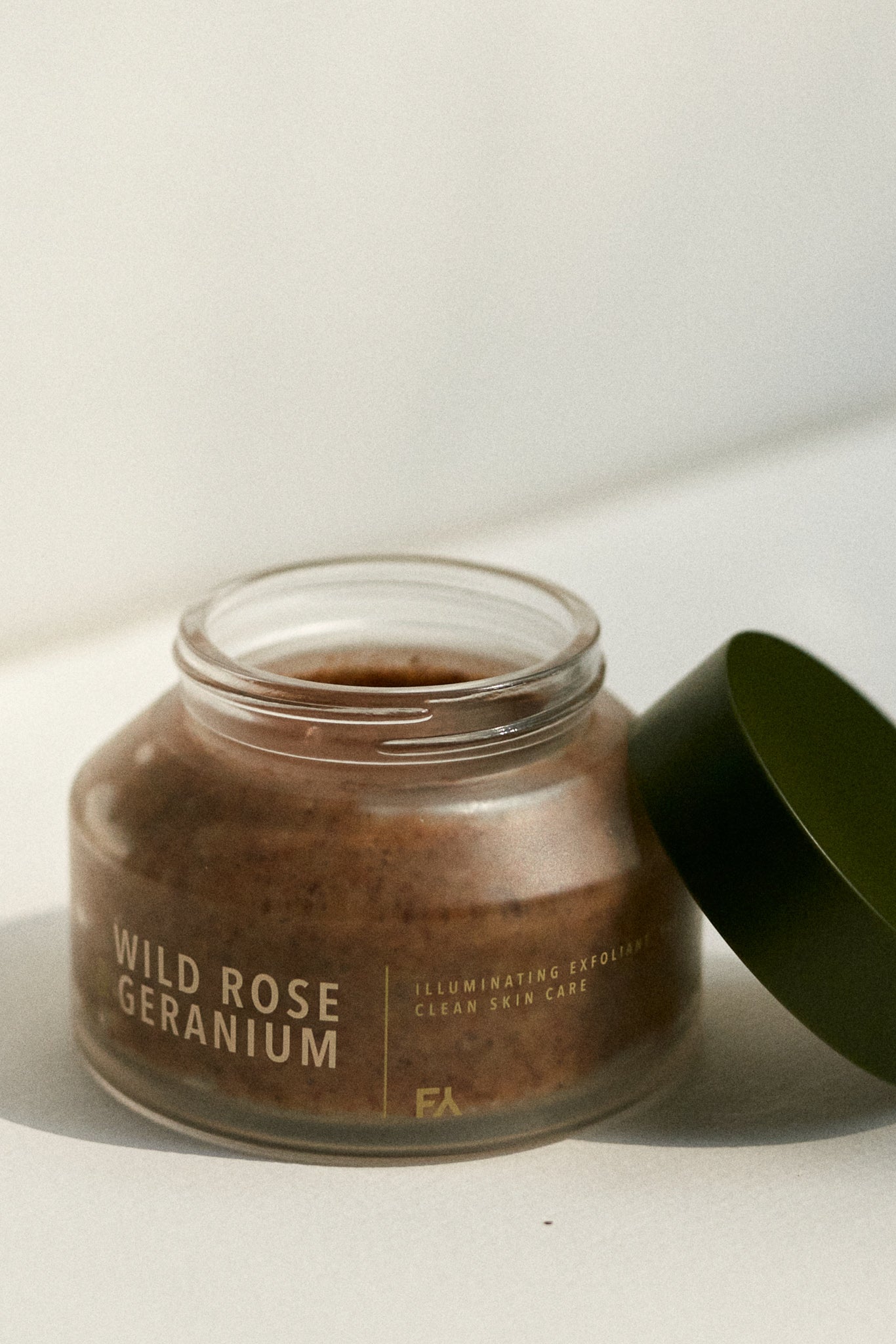 Still life picture of the Wild Rose & Geranium Illuminating Exfoliant by Fields of Yarrow jar with the lid open